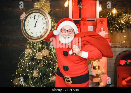 Smiling Santa mostra sveglia con cinque minuti a dodici. Babbo Natale - anziano bearded divertente. Ritratto di Santa sorpresa e divertente. Allegro Foto Stock