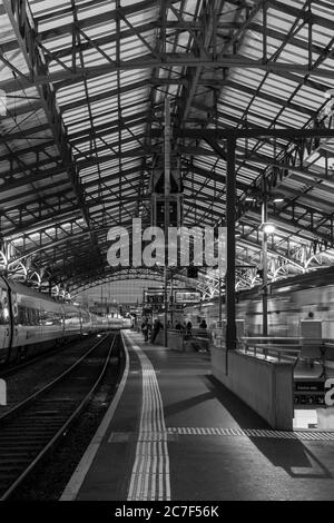 LOSANNA, SVIZZERA - 11 settembre 2019: Un colpo verticale di persone in attesa del treno in stazione in bianco e nero Foto Stock