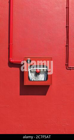 Immagine verticale di una superficie rossa con tubi metallici sottili - perfetto per uno sfondo rosso bellissimo Foto Stock