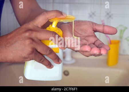 Disinfettante per le mani gel di alcol strofinare mani pulite igiene prevenzione di focolaio di coronavirus. Uomo che usa una bottiglia di sapone antibatterico igienizzante. Foto Stock