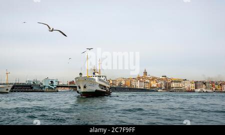 Barca sul Bosforo, dietro i quartieri Karakoey e Beyoglu con la Torre Galata, Istanbul, Turchia Foto Stock