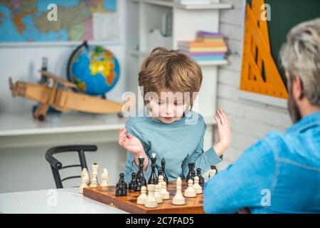 Ragazzo concentrato che sviluppa strategia di scacchi, giocando a gioco di tavolo. Ragazzino pensante. Scacchi, successo e vincita. Foto Stock