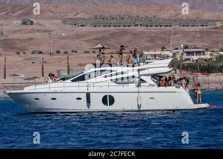 I visitatori a bordo di una barca di lusso si rinfrescano nelle acque del Golfo di Aqaba in Giordania. Aqaba ha eccellenti barriere coralline per immersioni e snorkeling. Foto Stock