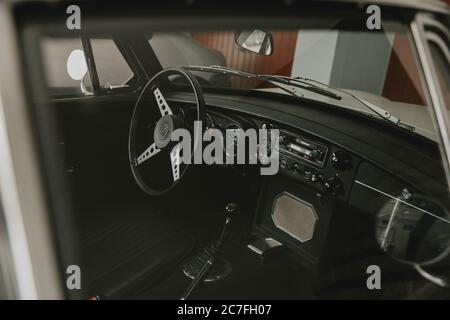 Interno scuro del classico postretrò parcheggiato speedster attraverso la finestra Foto Stock