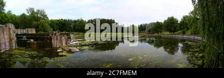 Vista panoramica estiva di un fiume con cascate in cemento. Slepian Water System. Minsk. Bielorussia. Foto Stock