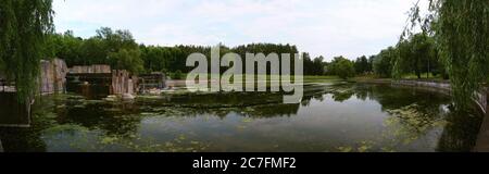 Vista panoramica estiva di un fiume con cascate in cemento. Slepian Water System. Minsk. Bielorussia. Foto Stock