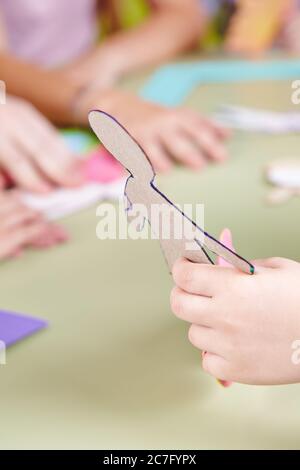 Bambini tinker in asilo con un modello in mano Foto Stock