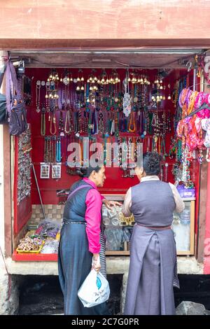 Due donne locali si impegnano in una conversazione al di fuori di un negozio di souvenir nella stazione collinare di McLeodgunj nello stato di Himachal Pradesh, nel nord dell'India Foto Stock