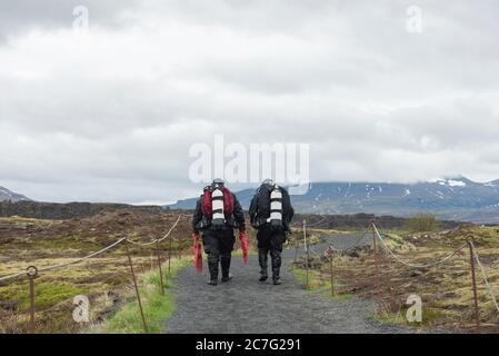 SILFRA, Islanda - 20 Maggio 2019: subacquei camminando su un percorso dopo una immersione Silfra rift, il luogo dove Eurasian e l'Americano targa tettonica Foto Stock