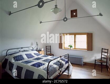 Camera da letto interna di un tetto di paglia, cottage con struttura in legno con argilla di scarico su una base di mattoni. Foto Stock