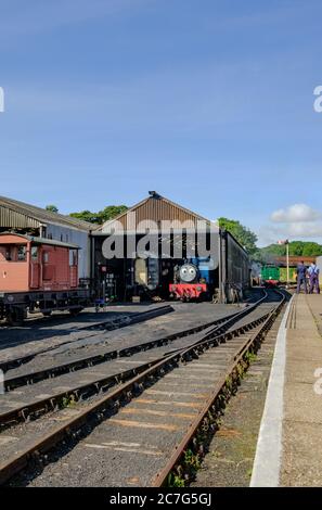 Locomotive a vapore in stile vintage, tra cui un popolare treno di personaggi per bambini visto in una locomotiva con un autista che si vede a piedi. Foto Stock