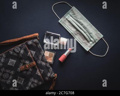 Borsa donna con rossetto, ombretto, gel igienizzante per le mani e maschera facciale. Foto Stock