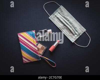 Borsa per il make up colorata con rossetto, ombretto, gel igienizzante per le mani e maschera facciale. Foto Stock