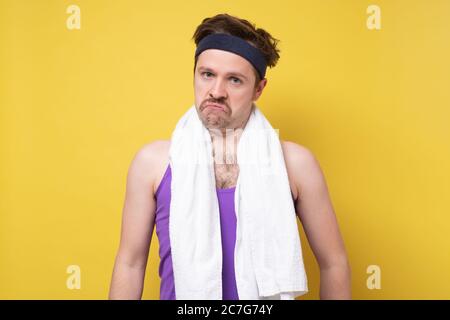 Giovane forma fisica l'uomo caucasico confuso, si sente dubbioso Foto Stock