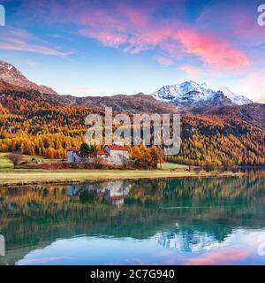 Vista mozzafiato autunnale del castello di Crap da Sass sul lago Silvaplana al tramonto. Ubicazione: Silvaplana, distretto di Maloya, regione Engadina, Cantone Grigioni, S. Foto Stock