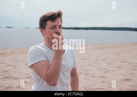 il giovane sta respirando pranayama seduto sul mare. Foto Stock