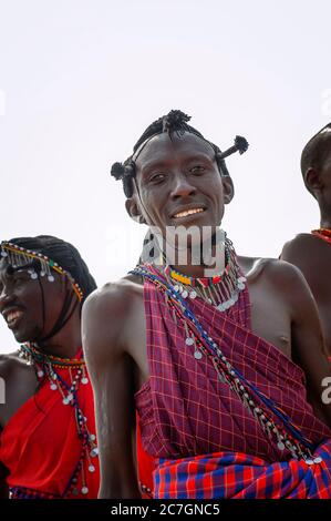 Uomo Maasai con abbigliamento tradizionale, in una danza tradizionale, nella Riserva Nazionale di Maasai Mara. Kenya. Africa. Foto Stock