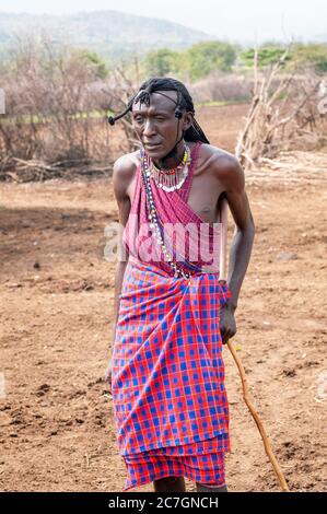 Uomo Maasai sorridente indossando abbigliamento tradizionale, nella Riserva Nazionale di Maasai Mara. Kenya. Africa. Foto Stock