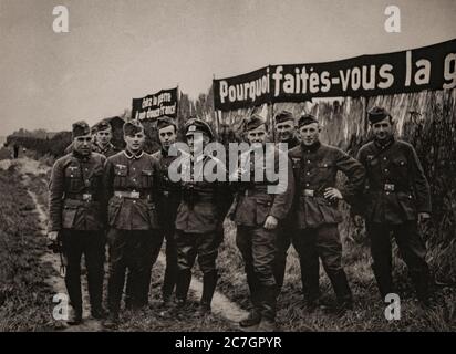 Dopo la battaglia di Francia, conosciuta anche come la caduta della Francia, l'invasione tedesca della Francia e dei Paesi Bassi nella primavera del 1940 durante la seconda guerra mondiale, un gruppo di soldati tedeschi si trova di fronte a manifesti propagandistici. Foto Stock