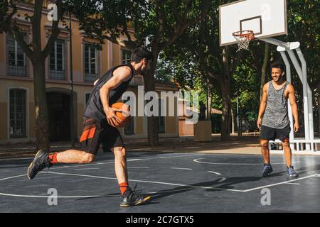 due giovani giocano a basket all'aperto Foto Stock