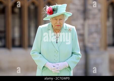 La regina Elisabetta II dopo aver conferito al capitano Sir Thomas Moore la sua cavallerezza durante una cerimonia al castello di Windsor. Foto Stock