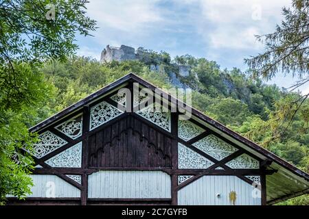 Cottage di legno sotto le rovine del castello, Muran pianura, repubblica slovacca, Europa centrale. Destinazione del viaggio. Tema architettonico. Foto Stock