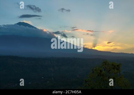 Tramonto sul vulcano Agung visto dalla barca. Stromboli è una delle otto isole Eolie e uno dei tre vulcani attivi a IBali, Indonesia Foto Stock