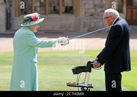 Il capitano Sir Thomas Moore riceve la sua cavallerezza dalla regina Elisabetta II durante una cerimonia al Castello di Windsor. Foto Stock