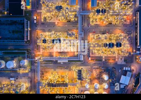 Vista aerea della fabbrica chimica e della centrale di raffineria petrolifera con molti serbatoi di stoccaggio e tubazioni al tramonto. Foto Stock