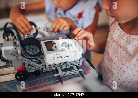 Due studentesse studiano in una classe robotica, assemblano un costruttore di robot Foto Stock