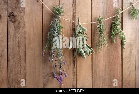 Erbe che asciugano di fronte ad un fondo rustico di legno Foto Stock