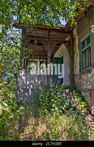 Triste vecchia casa di montagna abbandonata nelle colline e nella foresta. Oggi serve a proteggere i turisti dalla tempesta che li ha sorpresi. Foto Stock