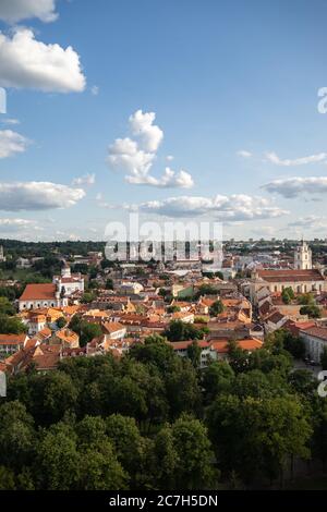Vista ad alto angolo di Vilnius circondata da edifici e vegetazione Sotto la luce del sole in Lituania Foto Stock