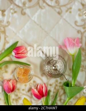 Tulipani multicolore con dolci orientali e una teiera ricamata tessuti Foto Stock