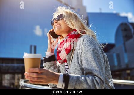 Adulto bella donna con caffè a piedi lungo la strada Foto Stock