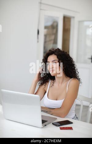 Giovane donna che lavora a casa con il computer portatile per lo shopping e il surf su internet Foto Stock