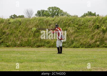 NIAGARA ON THE LAKE, CANADA - 20 giugno 2019: Attore vestito come un soldato del 18 ° secolo si sta preparando a sparare un musket. La posizione è Fort George a histo Foto Stock