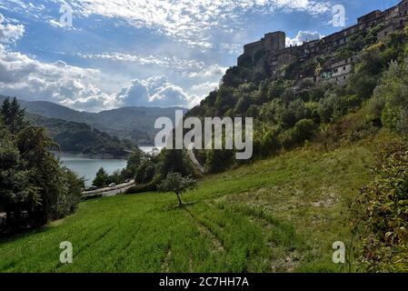 Una splendida vista su una collina, che guarda attraverso un lago con montagne e vecchi edifici in cima a una collina in primo piano Foto Stock