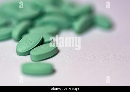 Selezione fuoco shot di pillole verdi su una superficie bianca Foto Stock