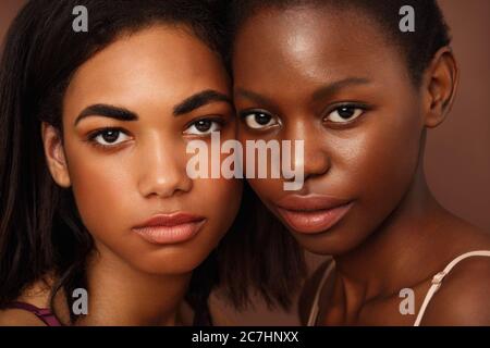 Primo piano ritratto di due belle donne afroamericane che guardano la fotocamera in studio Foto Stock
