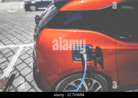 Un'auto elettrica per la ricarica presso la stazione di ricarica. Foto Stock