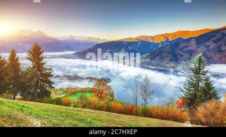 Spettacolare vista autunnale dei prati del lago alberi e montagne in Sell am See. L'alba sul lago è fantastica. Ubicazione: Zell am See, Salzburger Land, Aus Foto Stock