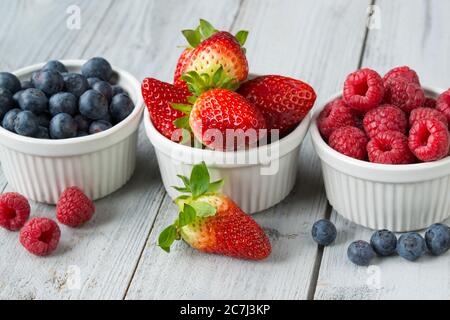 Bacche fresche e succose assortite del giardino in tre piccole ciotole Foto Stock