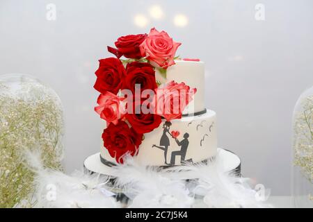 Torta di età decorata con rose sul tavolo Foto Stock