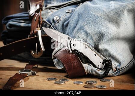 Pocketknife con i vecchi jeans sullo sfondo, pocketknife è uno di ogni giorno portare (EDC) articolo per gli uomini. Foto Stock