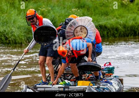 La popolazione locale partecipa ‘annuale corsa di zattere di   Ouseday’, pagaiando sui Rafts fatti in casa in aiuto della Carità da Lewes a Newhaven, River Ouse, Lewes, Regno Unito Foto Stock