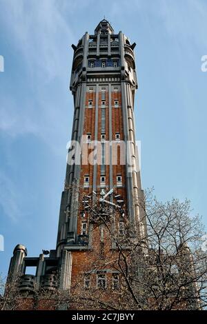 Immagine verticale ad angolo basso di un alto edificio con un orologio su di esso a Lille, Francia Foto Stock