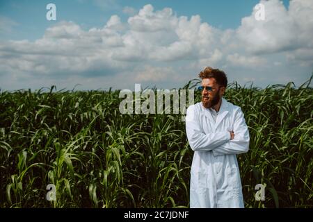 Agronomo tecnico caucasico maschile con computer tablet nel campo del mais controllo della qualità e la crescita delle colture per l'agricoltura. Comando campo mais Foto Stock