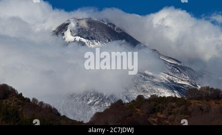 Etna, Parco Nazionale dell'Etna, Parco dell'Etna –´Etna, Etna innevata circondata da nuvole, foresta autunnale in primo piano Foto Stock