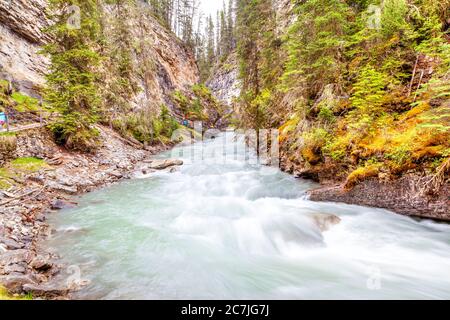 Le acque verde smeraldo dalle profonde piscine del Johnston Creek scorrono lungo il sentiero escursionistico del Johnson Canyon nel Banff National Park, dove le mura Foto Stock